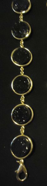 Pulseira dourada com pedras pretas
